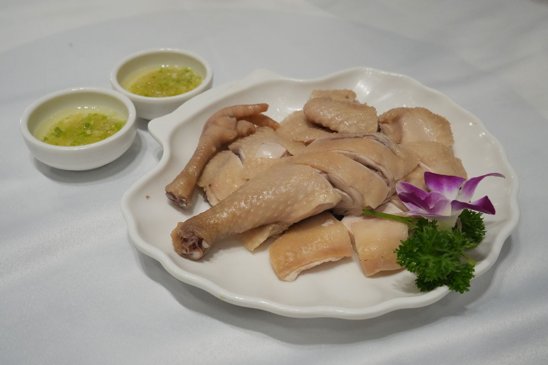 Đĩa gà luộc ăn kèm nước chấm và rau trang trí